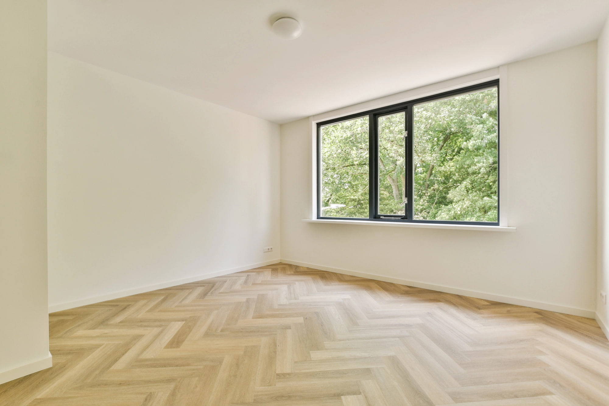 wooden herringbone flooring in white room
